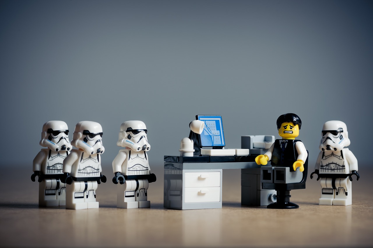 Stormtroopers and a lego minifigure at a desk